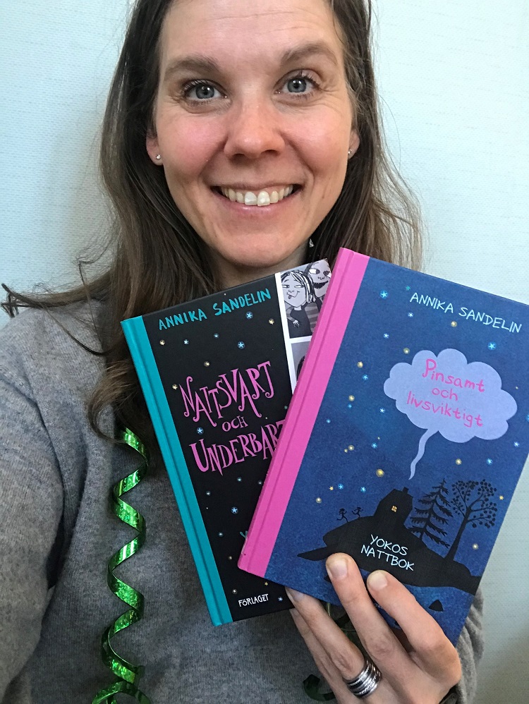 Läsambassadör Amanda Audas-Kass med en bunt böcker i handen.