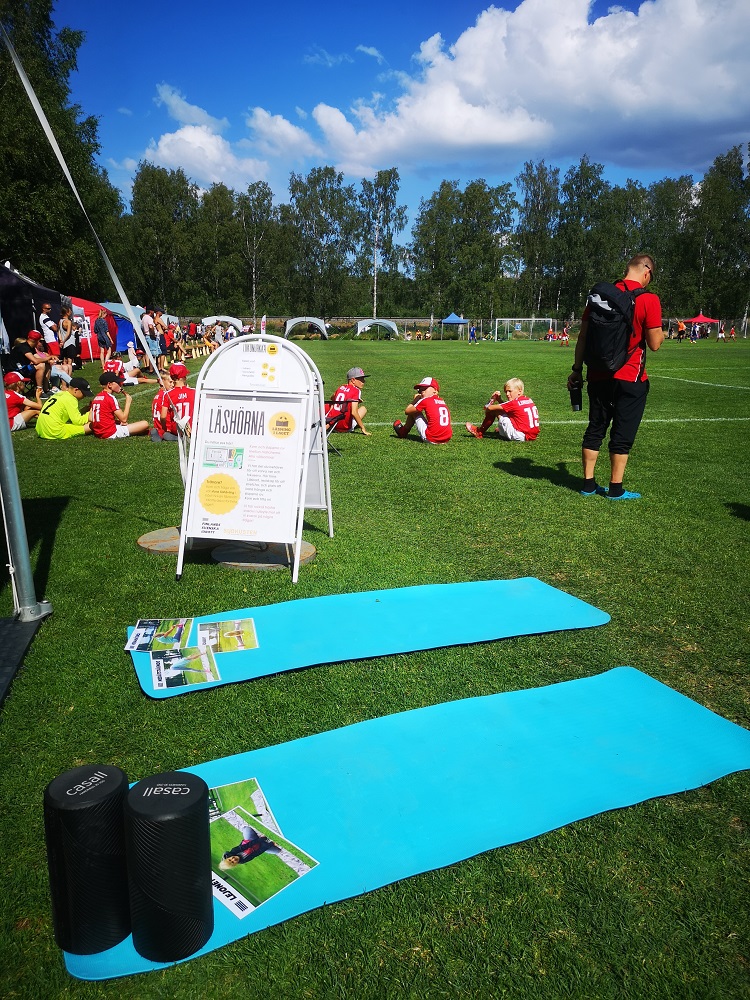 Utanför lästältet ses färggranna träningsmattor, längre bort skymtar man barn i träningskläder.