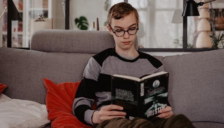 Ung pojke som sitter och läser.