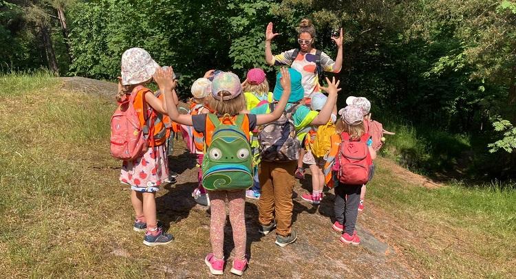 Emilia Christiansen instruerar en barngrupp ute i skogen.