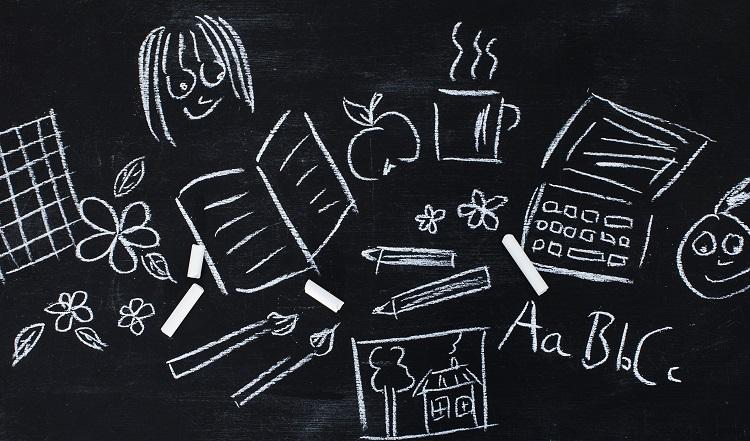 En gammaldags svart tavla med kritritade bilder och bokstäver.
