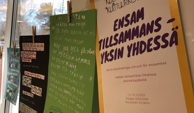 Ordkonstelevers alster upphängda med bykpinnar på ett bykstreck. Längst till höger affischen som berättar om utställningen Ensam tillsammans - Yksin yhdessä.