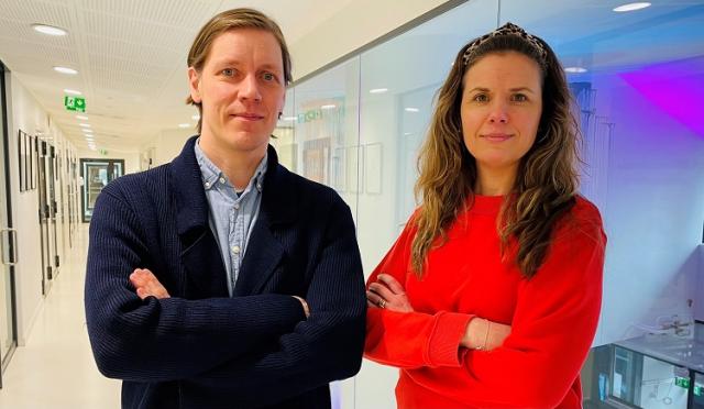 Matias Österberg i blått och Emilia Christiansen i rött står i korridoren utanför Sydkustens kontor, båda med armarna i kors.